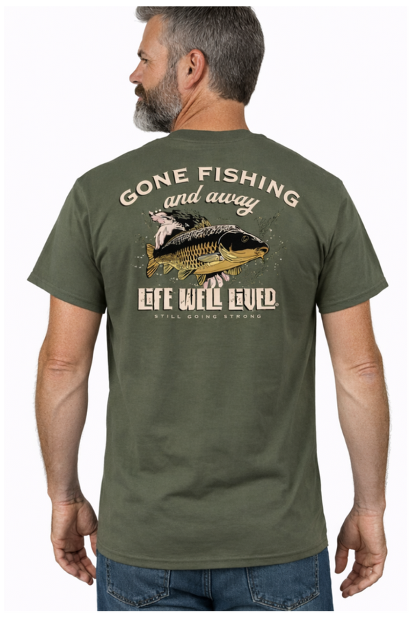 Back view of olive green Gone Fishing T‑shirt featuring large carp being released into the water with Gone Fishing and Away text above and Life Well Lived Still Going Strong branding below.