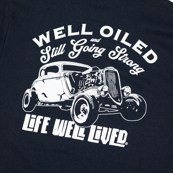 A classic black mens graphic Tee with simple white graphics depicting an old hotrod car on the back in white, the strapline reads 'Well Oiled & still Going Strong'