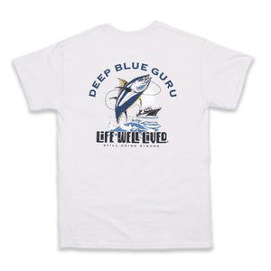A Mens graphic Tee, depicting a Tuna fish leaping from the water next to a fishing boat, the words Deep Blue Guru are arched above the image with the Life well lived log underneath, all on an Ice grey colour Tee shirt.