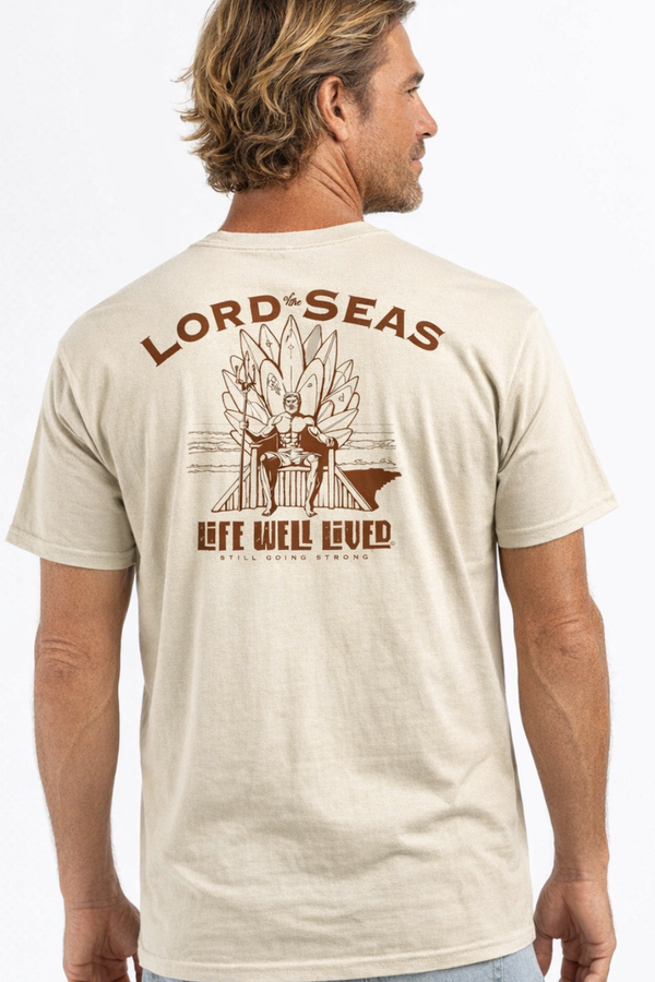 Man wearing a beige t-shirt with 'Lord of the Seas' graphic design.