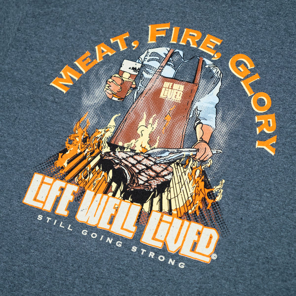 T-shirt graphic with 'Meat, Fire, Glory' text and a person holding a beer and apron. BBQ Steak.