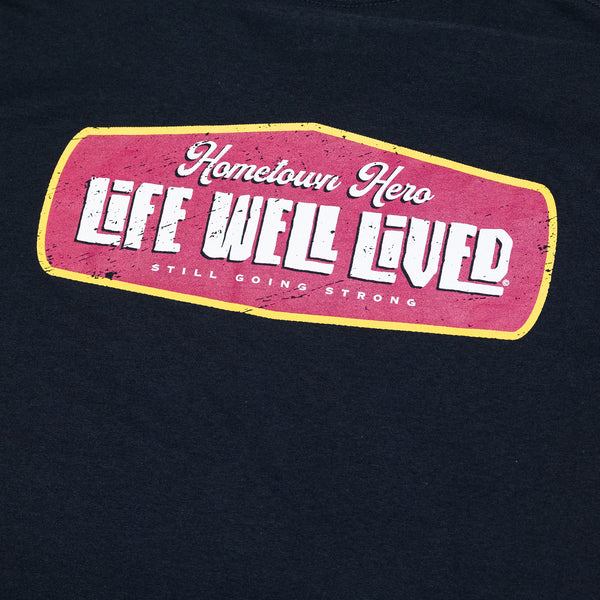 Mens graphic Tee in Black, red and yellow image on shoulders saying 'Life Well Lived Hometown hero'.
