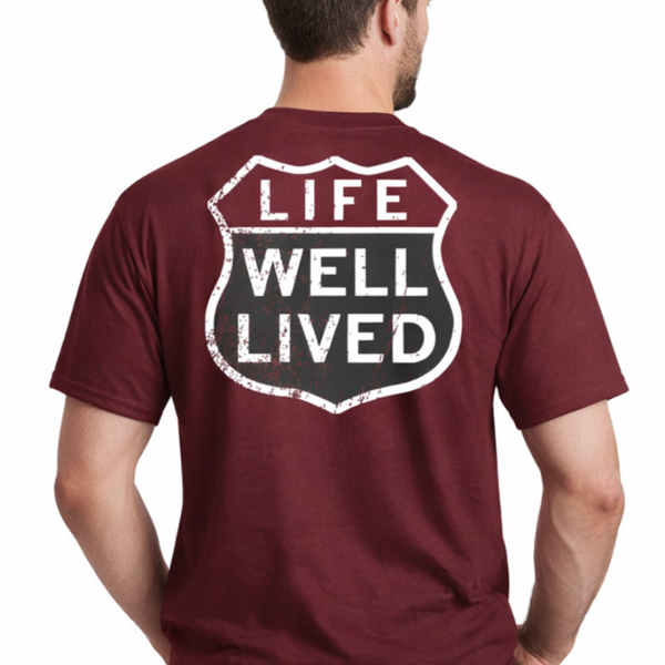 Maroon t-shirt with 'Life Well Lived' graphic on the back, worn by a person.