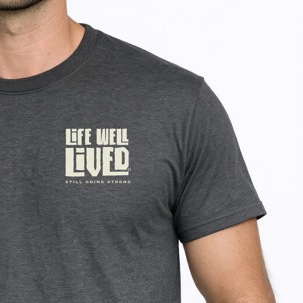 Man wearing a dark gray t-shirt with 'Life Well Lived' text on a white background